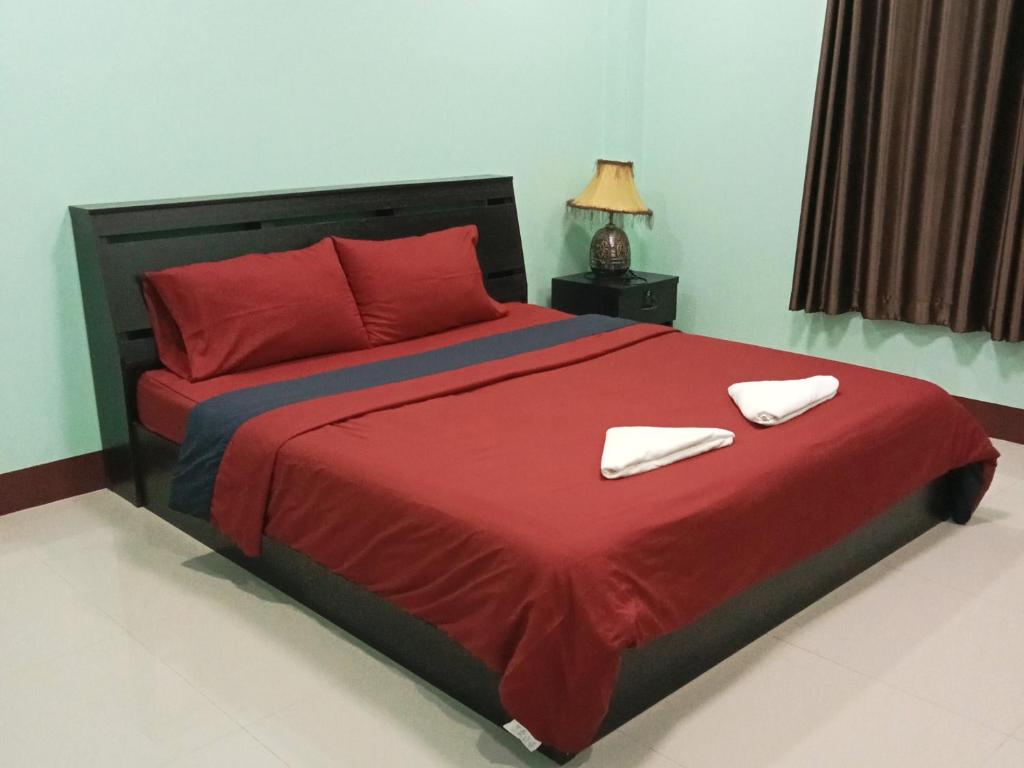 um quarto com uma grande cama vermelha com almofadas vermelhas em หม่อนเมือง รีสอร์ท em Chiang Rai