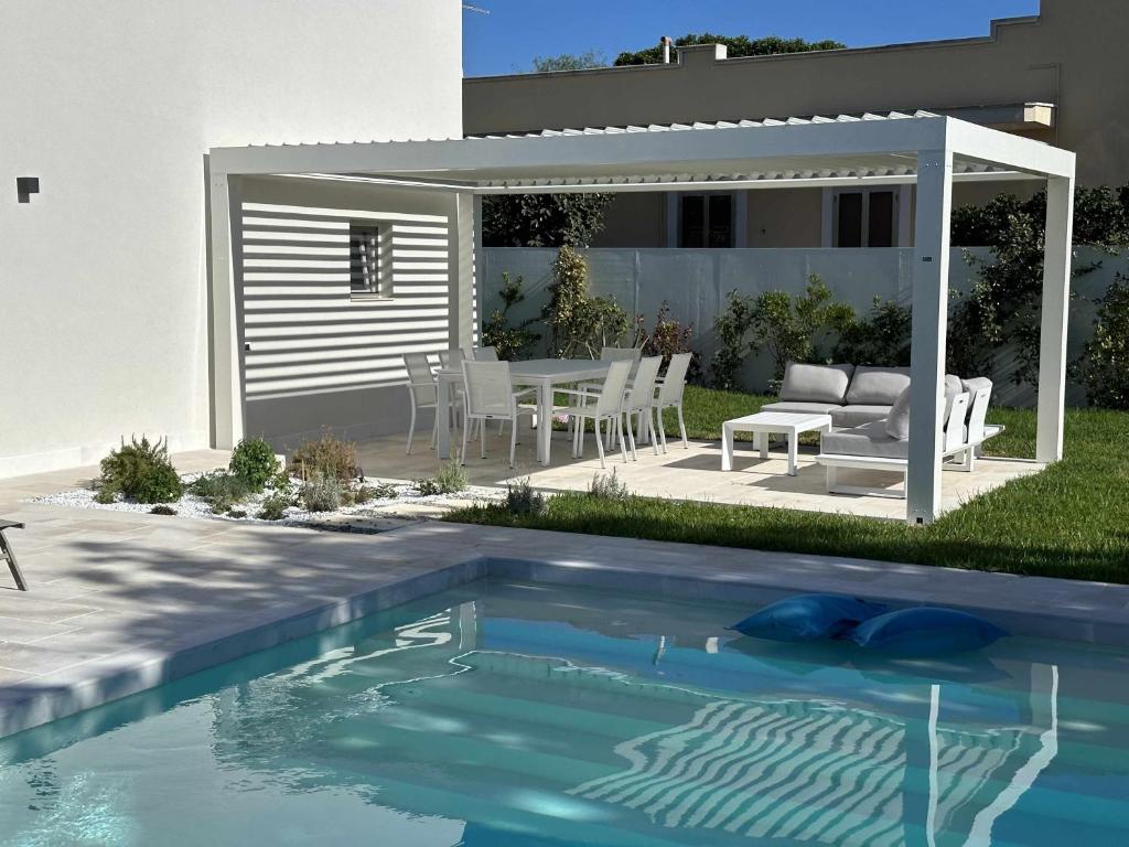 un cortile con piscina, tavolo e sedie di Casa del Sol Luxury Estate Puglia a Leporano Marina
