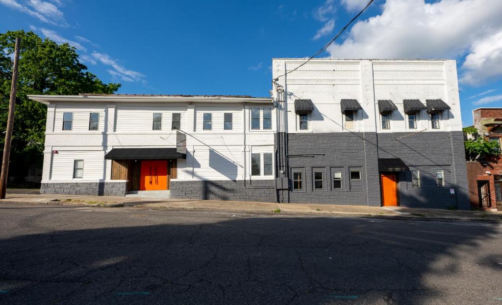 a white building with orange doors next to a street at Five10 Hot Springs in Hot Springs
