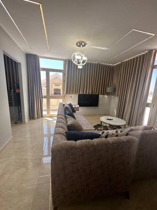 ein Wohnzimmer mit einem Sofa und einem Tisch in der Unterkunft Luxury Rooftop WiFi, AC, BBQ in Rejiche