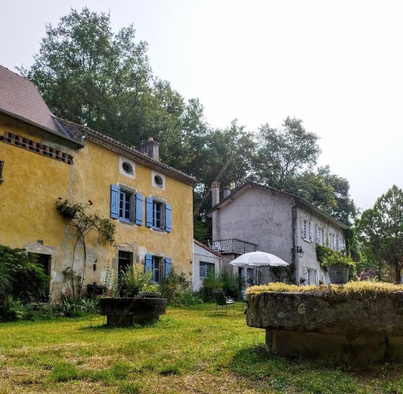 un grupo de edificios y un paraguas en un patio en Moulin de chez Joyeux, en Thiat