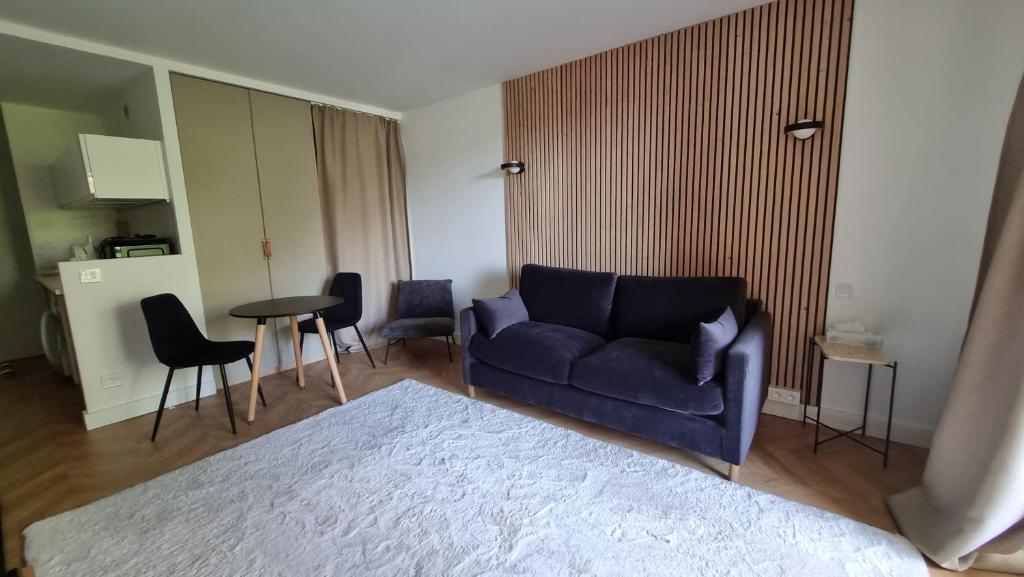 uma sala de estar com um sofá azul e uma mesa em Cosy Studio near Monaco SEA VIEW Balcony em Beausoleil