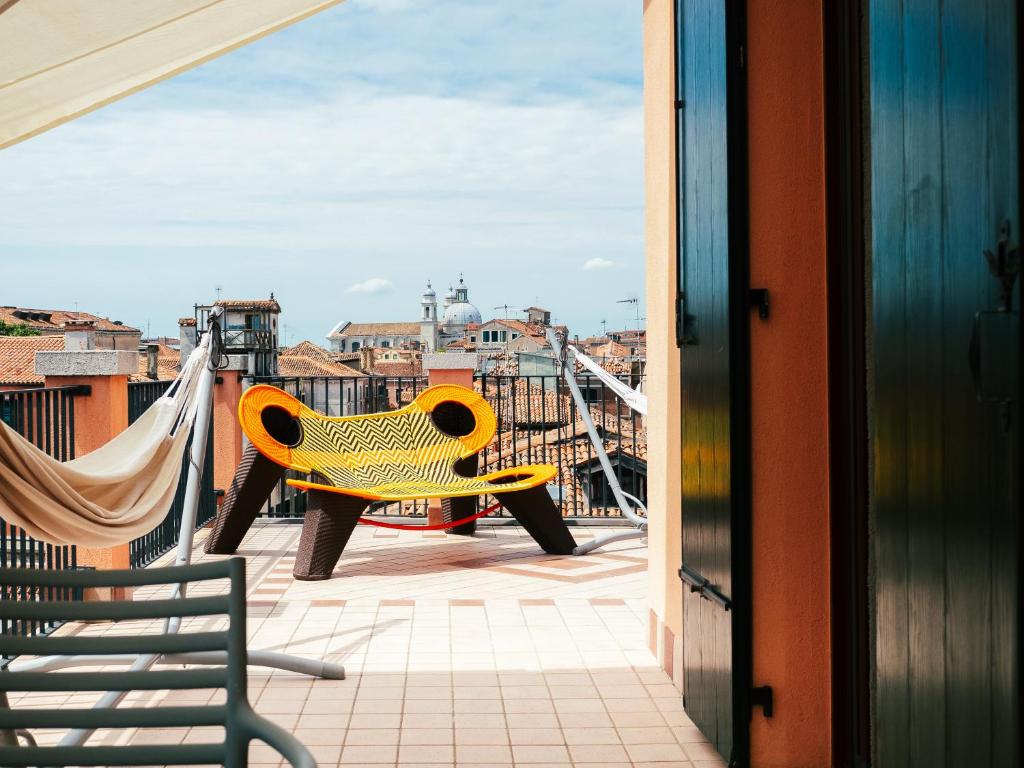 um banco amarelo sentado em cima de um telhado em Le Terrazze em Veneza