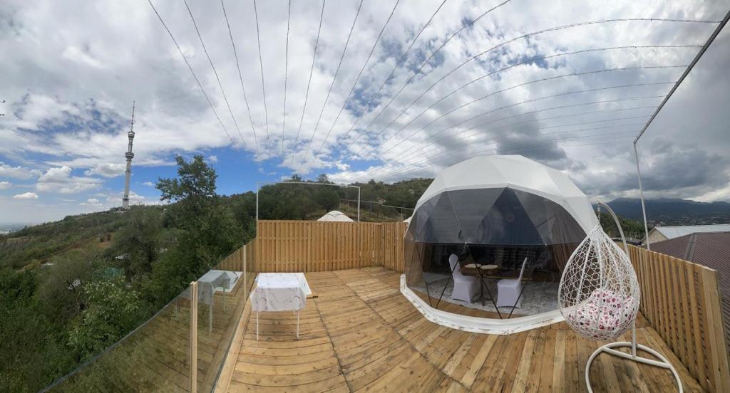 una casa con una tienda en una terraza de madera en Panorama Almaty en Almaty