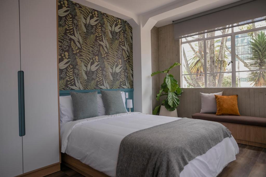 Un dormitorio con una cama grande y una ventana en 5Q House Quinta Camacho en Bogotá