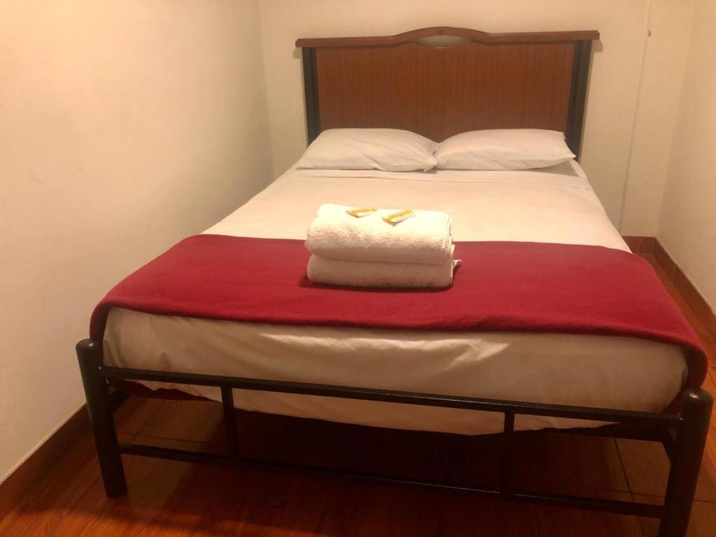 a bed with two folded towels on top of it at NEW INKAWASI ( COZY HOUSE) in Lima