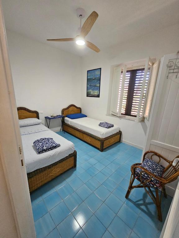 sypialnia z 2 łóżkami i wentylatorem sufitowym w obiekcie Villetta in stile mediterraneo w mieście Fort Village