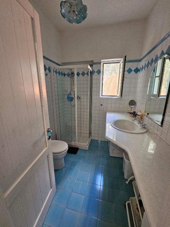 łazienka z umywalką, toaletą i prysznicem w obiekcie Villetta in stile mediterraneo w mieście Fort Village