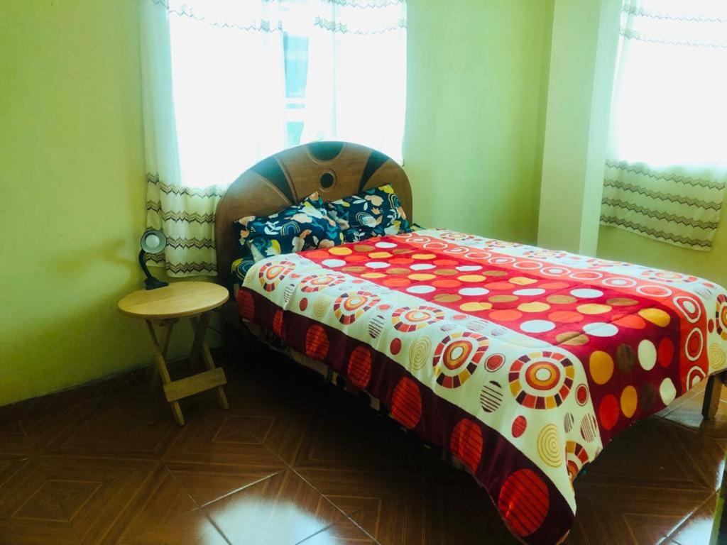 Un dormitorio con una cama con una manta de colores. en Habitación simple, en Urubamba