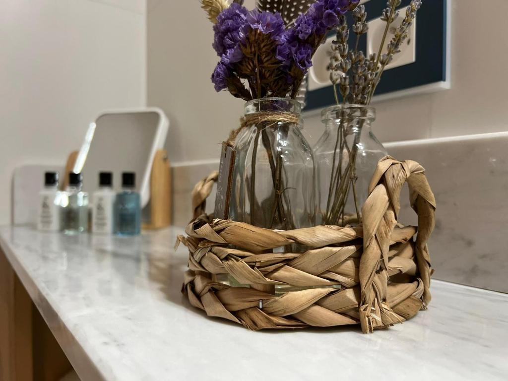 two vases sitting on a counter with flowers in them at Mes à Moi in Pezenas - Studio &amp; patio privatif - O Pitchoun in Pézenas