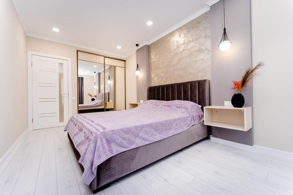 a bedroom with a large bed and a mirror at 2-Bedroom Family Grandeur Apartment in Chişinău