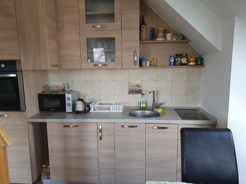 a small kitchen with a sink and a microwave at Apartman Malina in Zlatibor