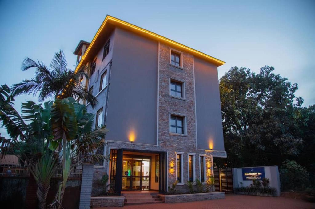 un gran edificio de ladrillo con puerta delantera en Blueberries Hotel en Entebbe