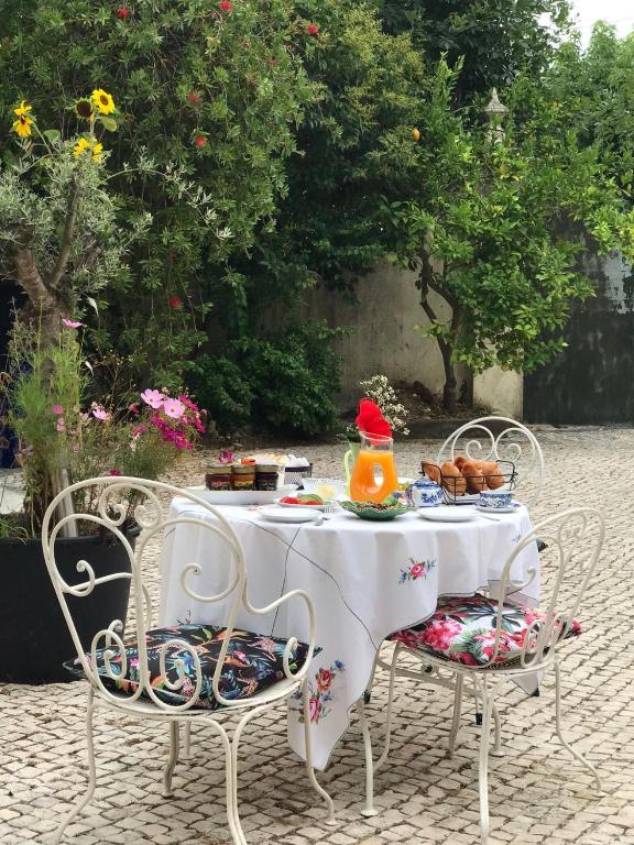 a white table and chairs with food on it at Casa Beija-Flor in Mogofores