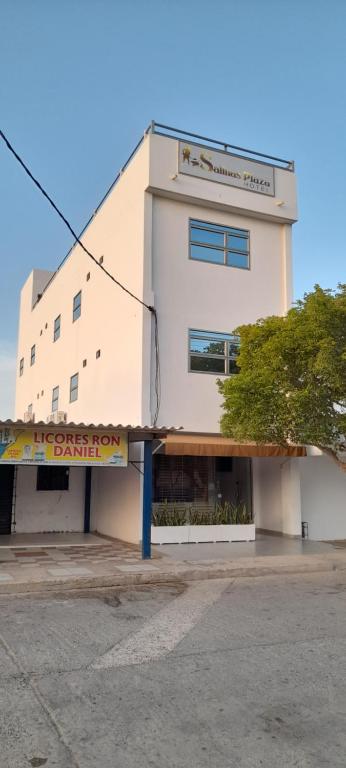 een wit gebouw met een bord ervoor bij SALINAS PLAZA HOTEL in Manaure