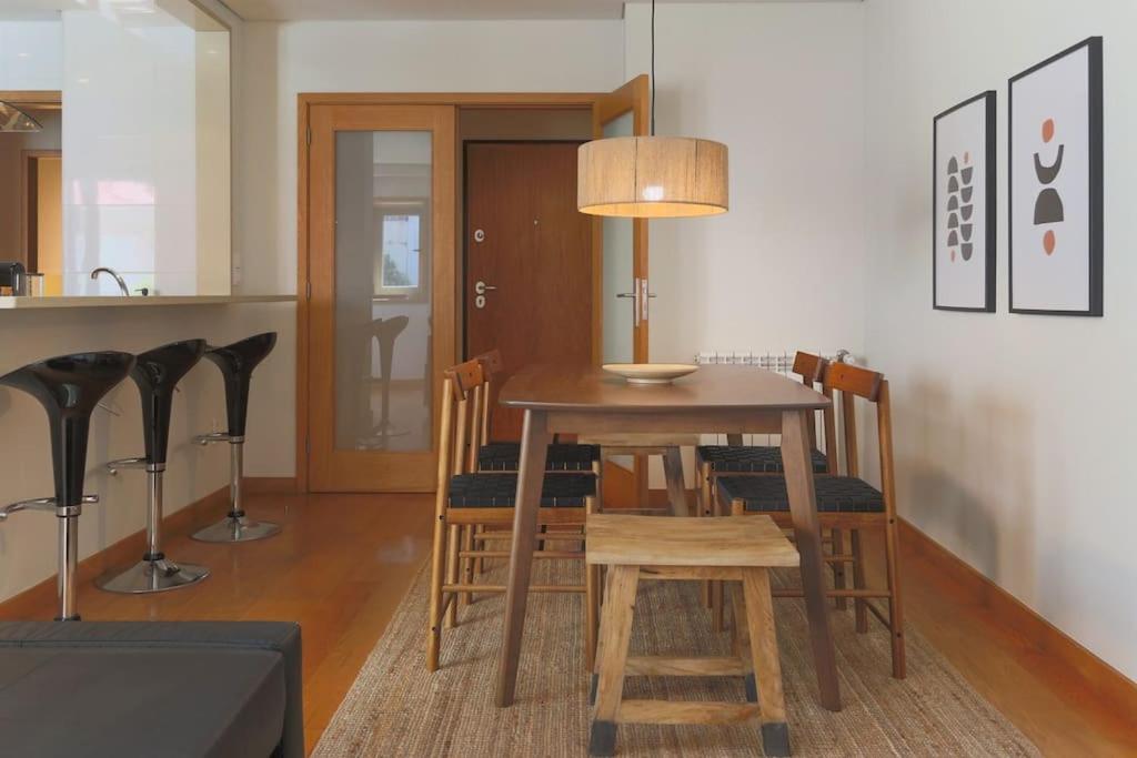 a dining room with a table with chairs and a lamp at Republica Deluxe Apartment in Vila Nova de Gaia