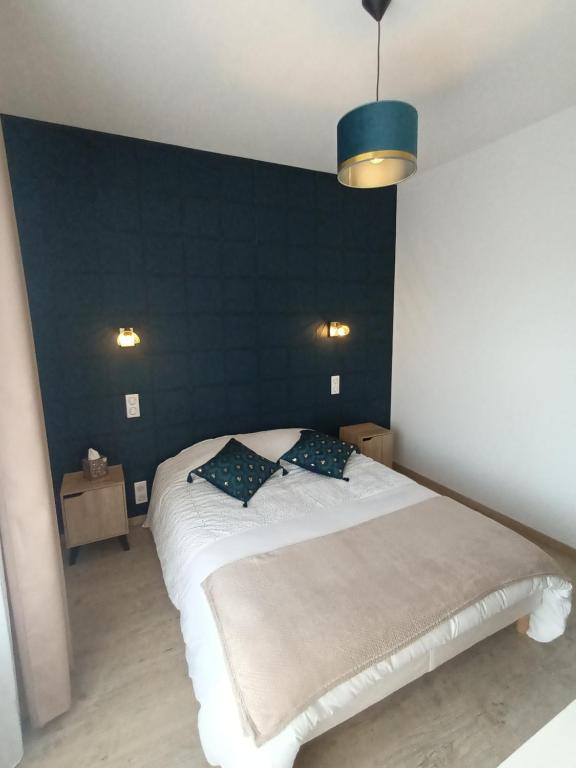 1 dormitorio con 1 cama grande y pared azul en Centre, Soulages, Amphithéâtre - clim balcon parking, en Rodez