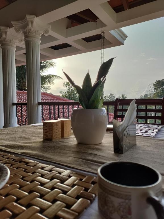 a table with a cup of coffee and a plant on it at The Cana's Coorg in Ammatti