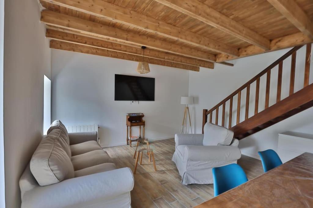 a living room with a couch and chairs and a tv at Gîte Louannec - Ty Bleiz in Louannec