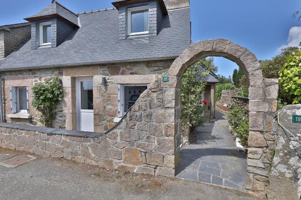a stone house with an archway in front of it at Gîte Louannec - Ty Bleiz in Louannec