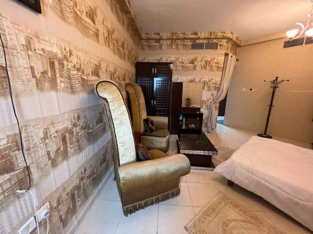 Zimmer mit Sofa, Bett und Wand in der Unterkunft شقة مفروشة دبي in Ajman 