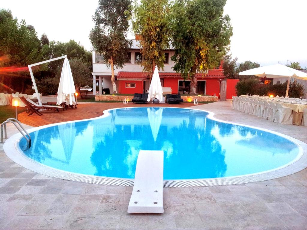 una grande piscina con acqua blu di fronte a un edificio di Alfieri Cottage a Ruvo di Puglia