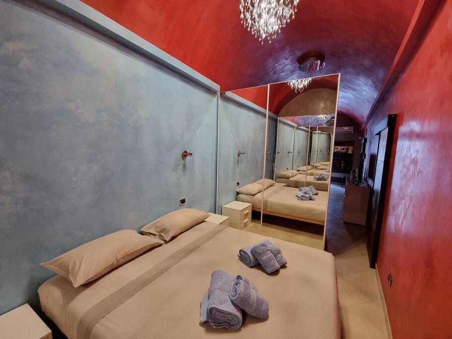 1 dormitorio con 2 camas y espejo en Bilocale tipico, nel centro del Salento, en Galatina