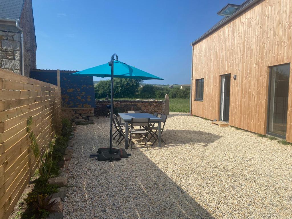 una mesa con sombrilla junto a un edificio en La cabane du banc José, en Le Rozel