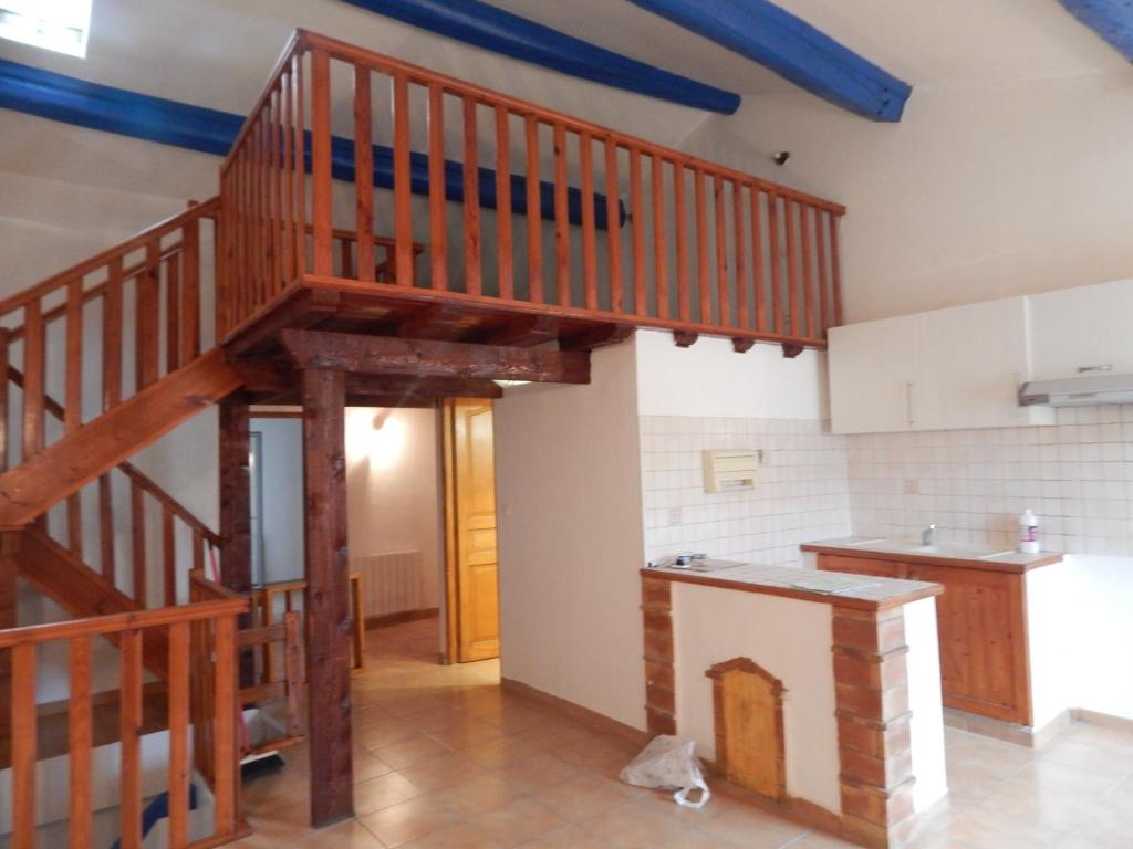 - une cuisine avec un escalier en bois dans une chambre dans l'établissement F3 HOCHE 2 éme étage, à Coursan