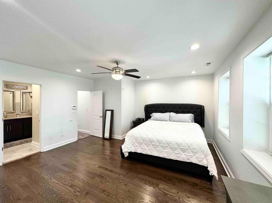- une chambre avec un lit et un ventilateur de plafond dans l'établissement Beautifully Renovated House 10 mins from Downtown, à Chicago