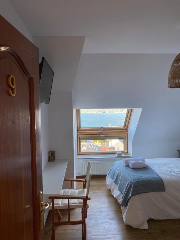 een slaapkamer met een bed en een raam bij EL TRASTERO DE PALMERO in A Coruña