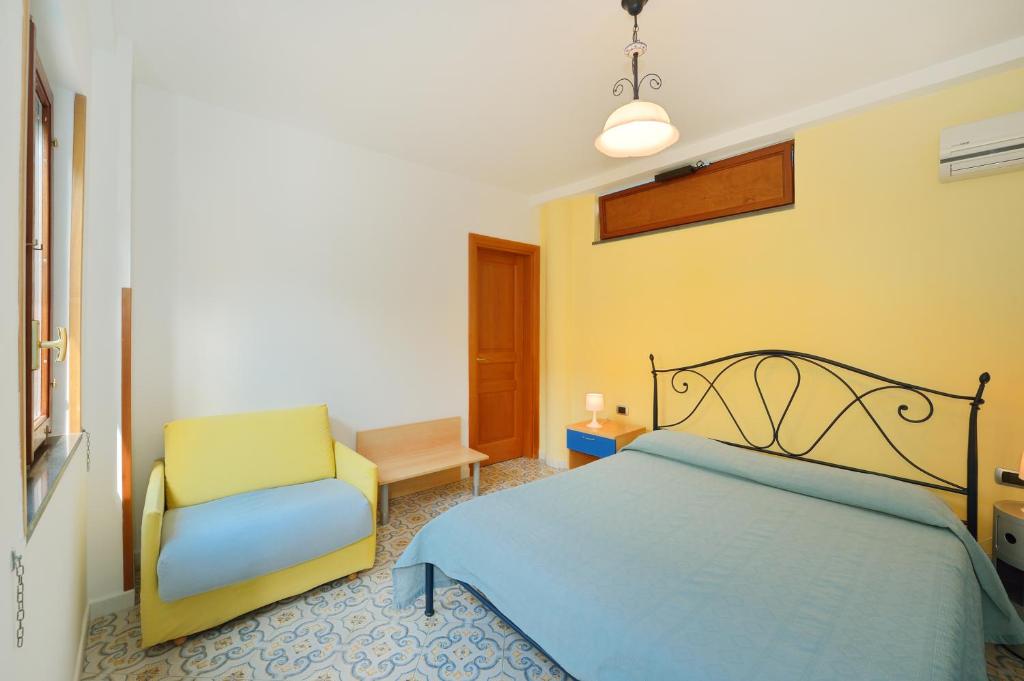 a bedroom with a bed and a chair at La Capannina in Procida