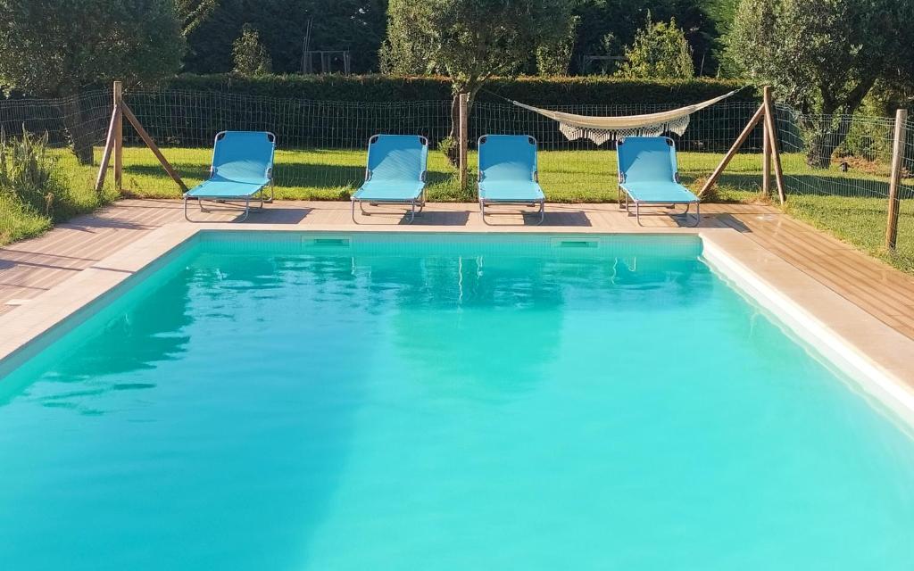 una piscina con sedie blu in un cortile di Sunset River Villa, Lisbon ad Alcochete