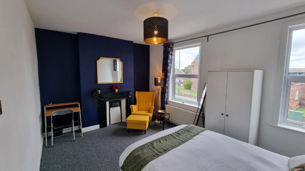 a bedroom with blue walls and a bed and a chair at Luxury double room with kitchen facilities in Nottingham