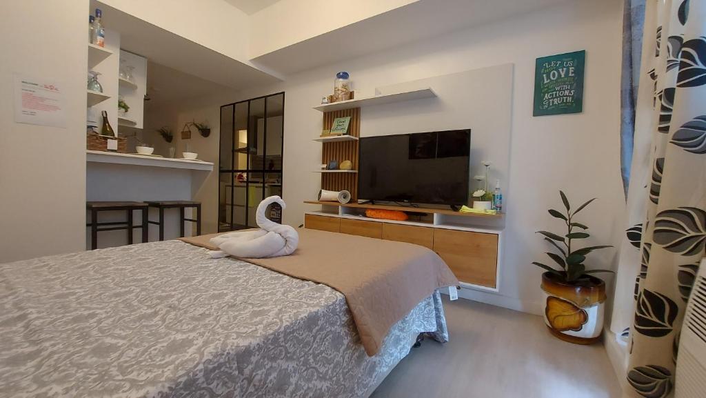 um quarto com uma cama com um cisne em SDC lovely place azure north em San Fernando