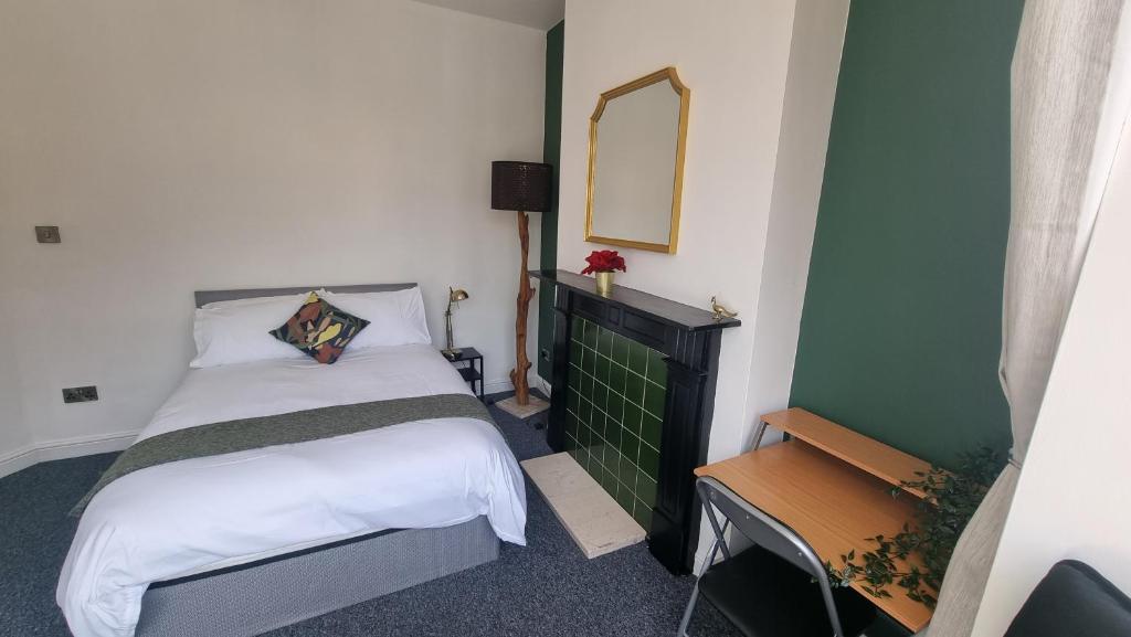 a small bedroom with a bed and a mirror at Double Room With Kitchen Facilities in Nottingham
