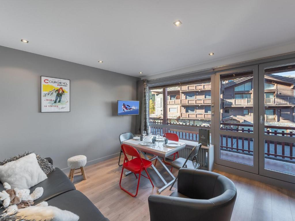 un salon avec un canapé et une table avec des chaises dans l'établissement Appartement central à Courchevel 1650 avec accès direct aux pistes et WiFi - FR-1-563-117, à Courchevel