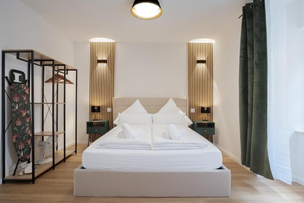 a white bed in a room with two lamps at NEU / Design / Altstadt / Küche / NETFLIX in Bad Säckingen