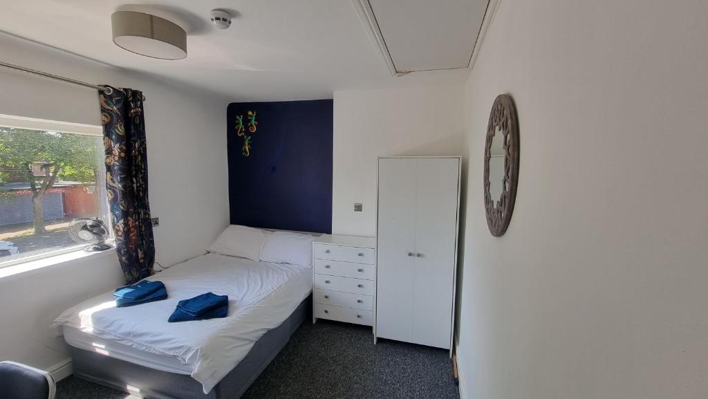 ein kleines Schlafzimmer mit einem Bett und einem Spiegel in der Unterkunft En Suite room with kitchen facilities in Nottingham