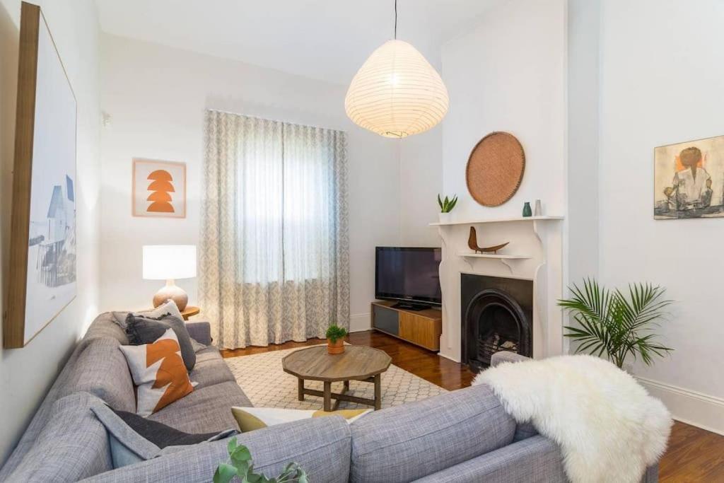 a living room with a couch and a fireplace at Blackbird at Arlos Glenelg South in Glenelg