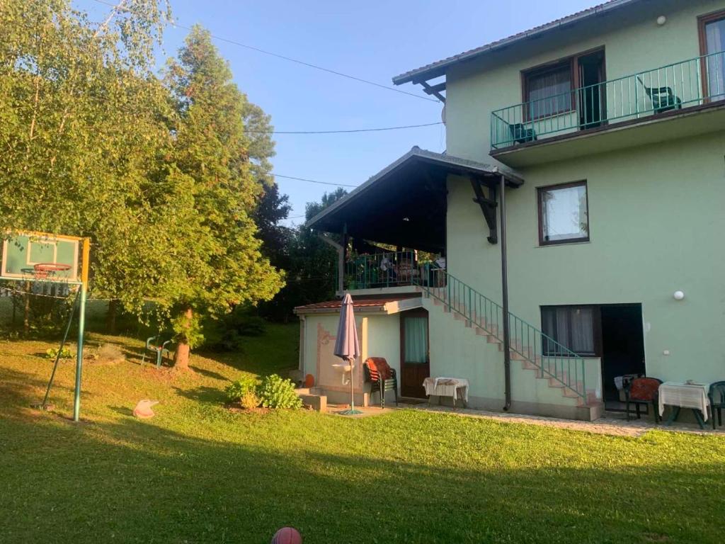 a large white house with a yard with a patio at Vila Dalmatinka in Gornja Toplica