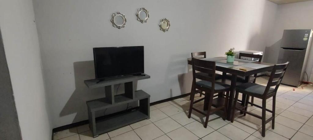 a dining room with a table with chairs and a television at Depa M&J Cd. Juarez in Ciudad Juárez