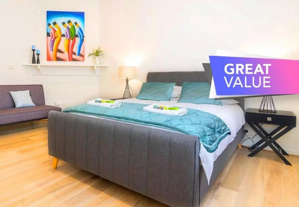 a large bed with a sign that reads great value at Minutes from the beach shops and parks in Glenelg