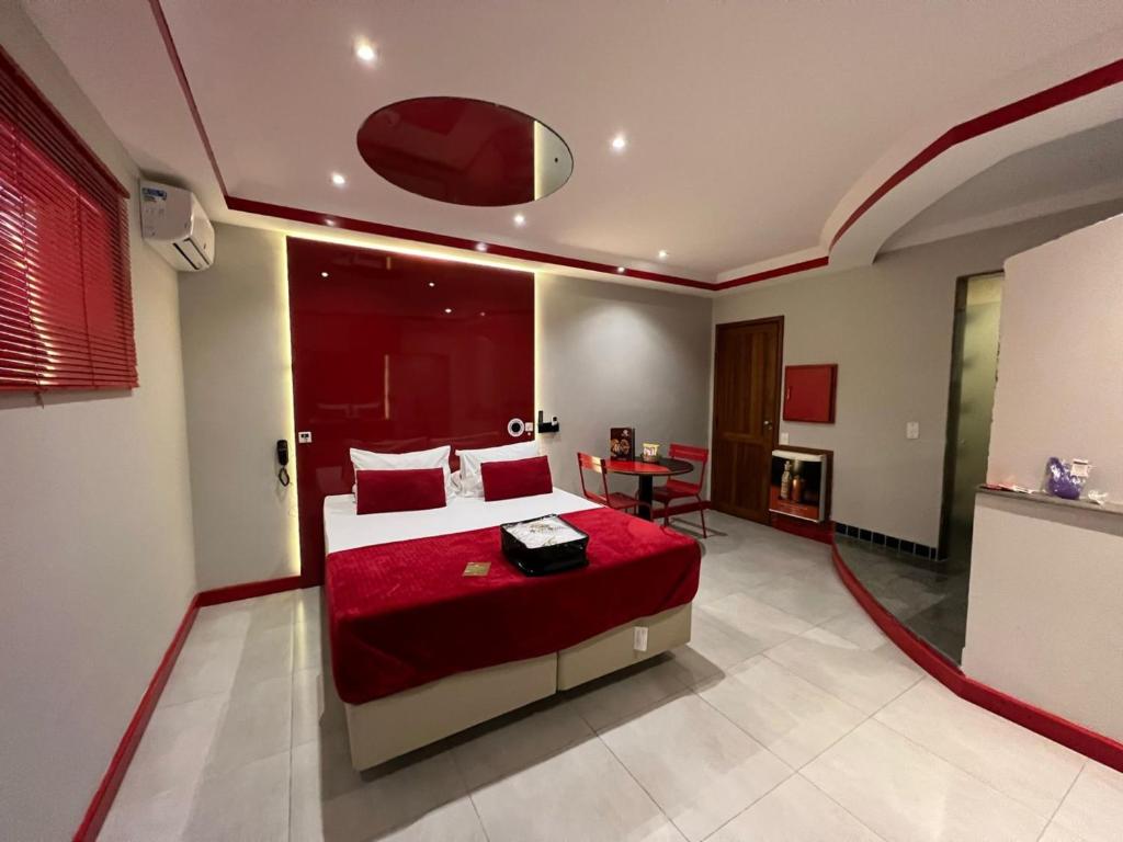 um quarto com uma cama grande e um cobertor vermelho em KANKUN MOTEL E POUSADA -Adult only em Sorocaba