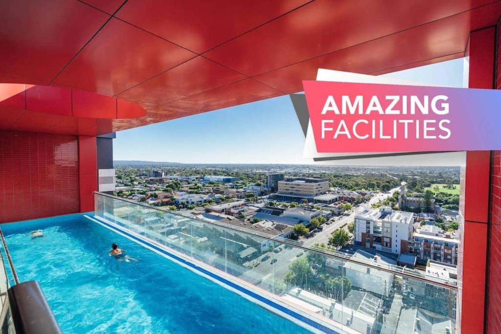 a person swimming in a swimming pool in a building at Sky High on Grote - An Elevated Inner-City Stay in Adelaide