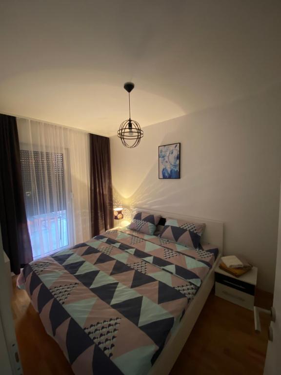 a bedroom with a bed with a checkered comforter at R&G apartman in Bijeljina