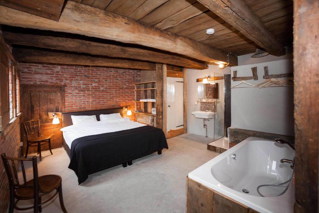een slaapkamer met een bed en een bad bij NorgerStee in Norg