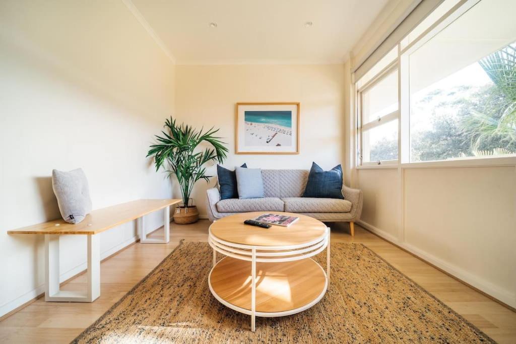 a living room with a couch and a table at Beachy Keen on Moseley - Laid-Back Stay by the Jetty in Glenelg