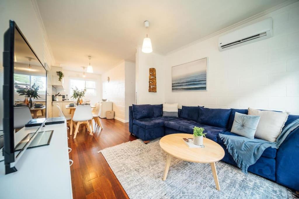 a living room with a blue couch and a table at Urban Beach Shack - Steps to Grange Beach & Café in Grange