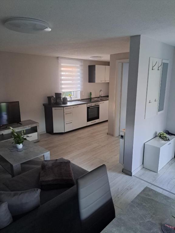 a living room with a couch and a kitchen at Haus Angel-am See in Heldrungen